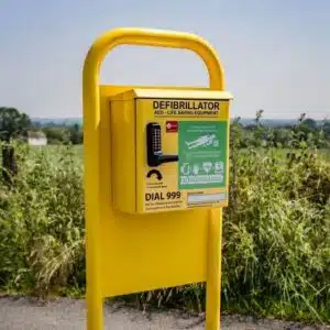 Bright yellow hoop bar mount with a defibrillator and AED life-saving equipment, ensuring quick and easy access during emergencies.