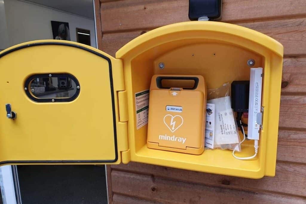 An AED defibrillator located outdoors in a lockable defibrillator cabinet.