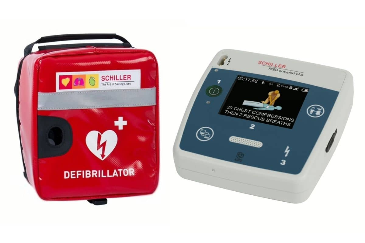 A SCHILLER FRED easyport plus defibrillator with on-screen instructions next to a red carry case.