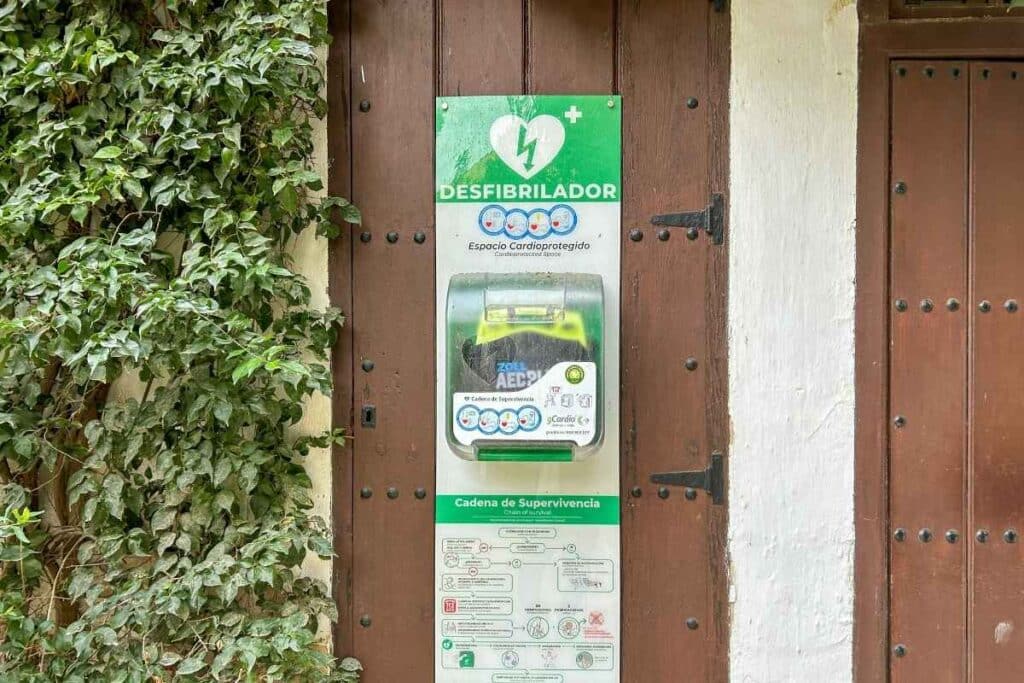 An external, wall-mounted defibrillator with scratches on the outer casing.