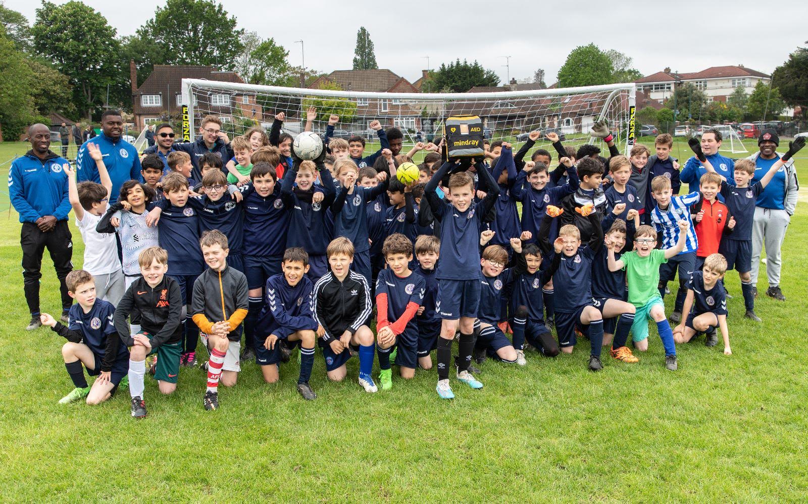 Children's football team holding a Mindray AED - Promoting child-specific defibrillation and emergency care in sports activities