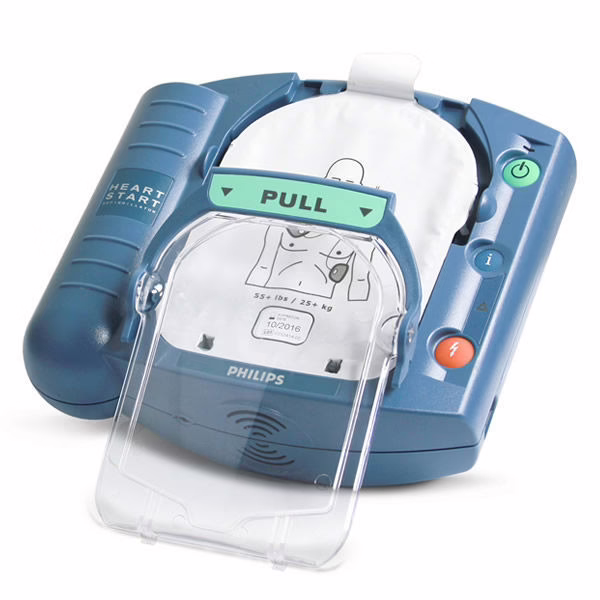 A close-up image of a Philips HeartStart HS1 defibrillator with an open lid showing the "Pull" tab and electrode pads ready for use. The defibrillator is designed for both trained and untrained users to respond to cardiac emergencies.