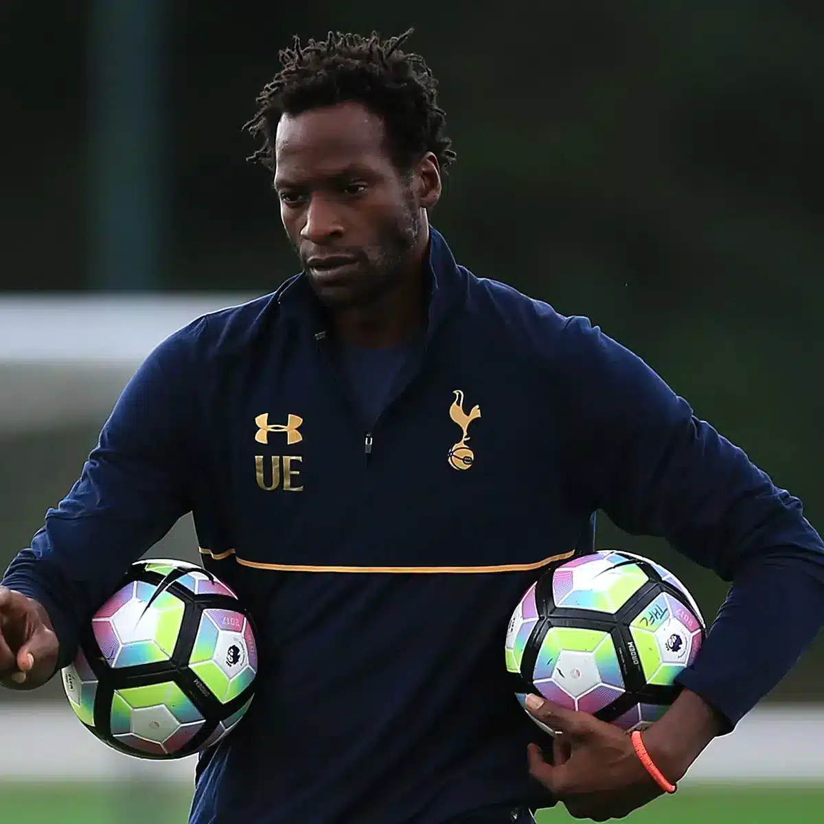 Uho Ehiogu holding two footballs, in Tottenham Hotspur kit.