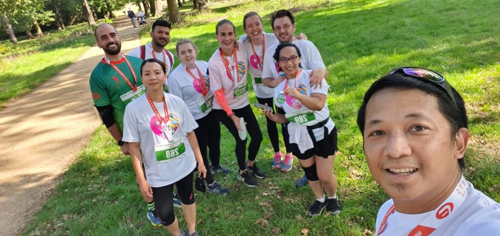 A group of runners celebrating after a charity run, promoting the global impact of defibrillators and raising awareness about life-saving devices.