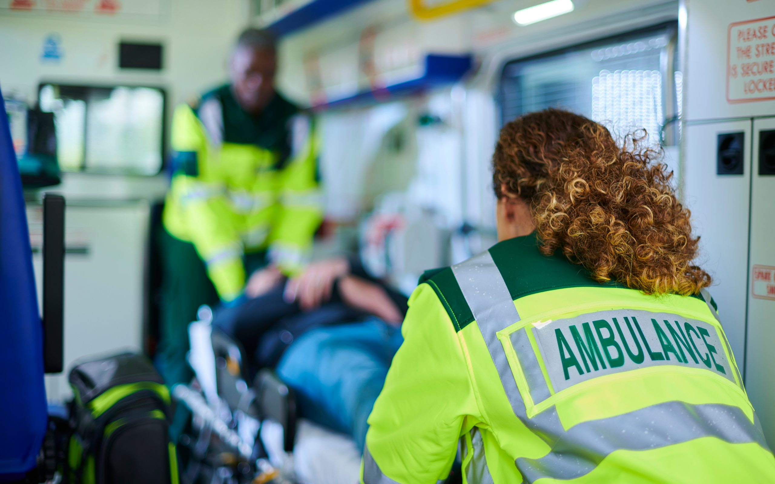 Emergency medical team administering life-saving care to a patient in an ambulance, showcasing rapid response after defibrillator use.