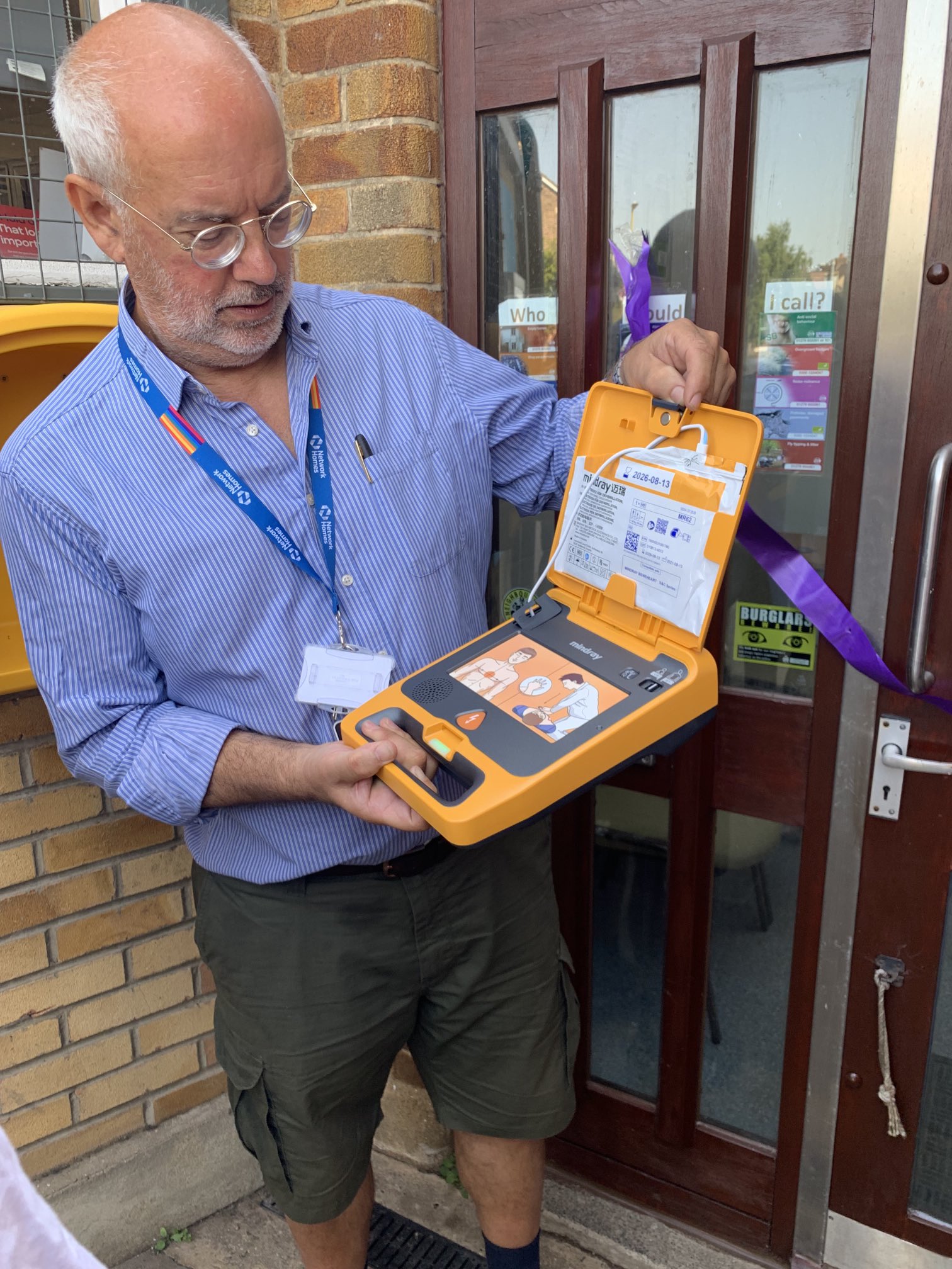 Defib World staff member demonstrating the use of a defibrillator outside, showcasing the importance of AEDs for emergencies