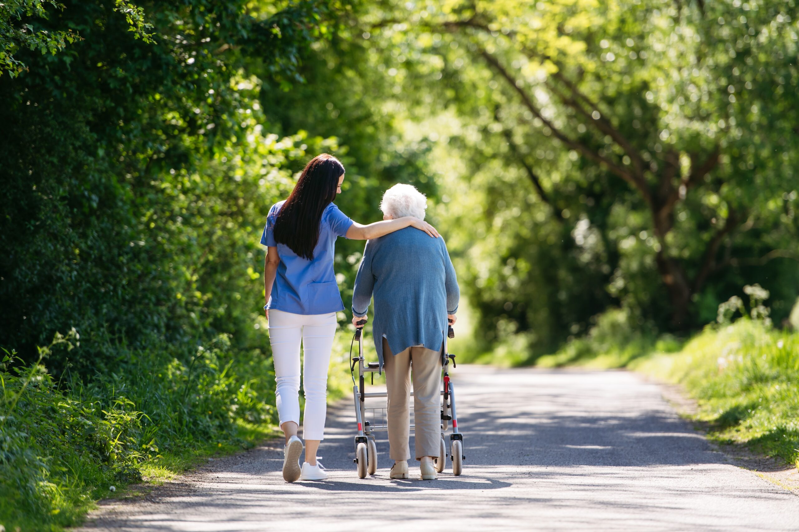 Caregiver helping an elderly person with a walker, representing the importance of CPR and AED use for senior care in emergencies