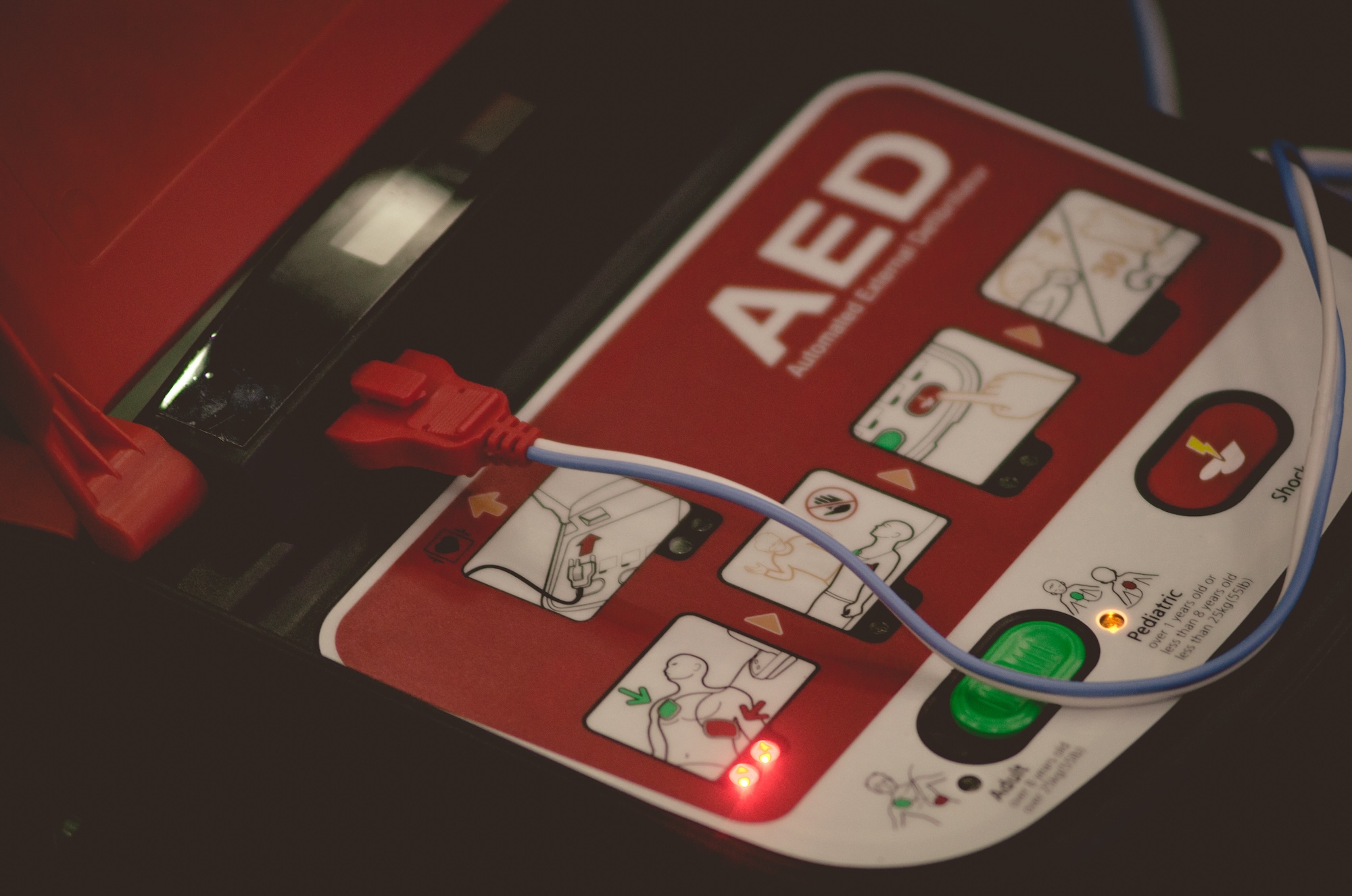 Close-up of an AED device showing electrode placement instructions for defibrillation, emphasizing the importance of proper AED usage in cardiac emergencies.