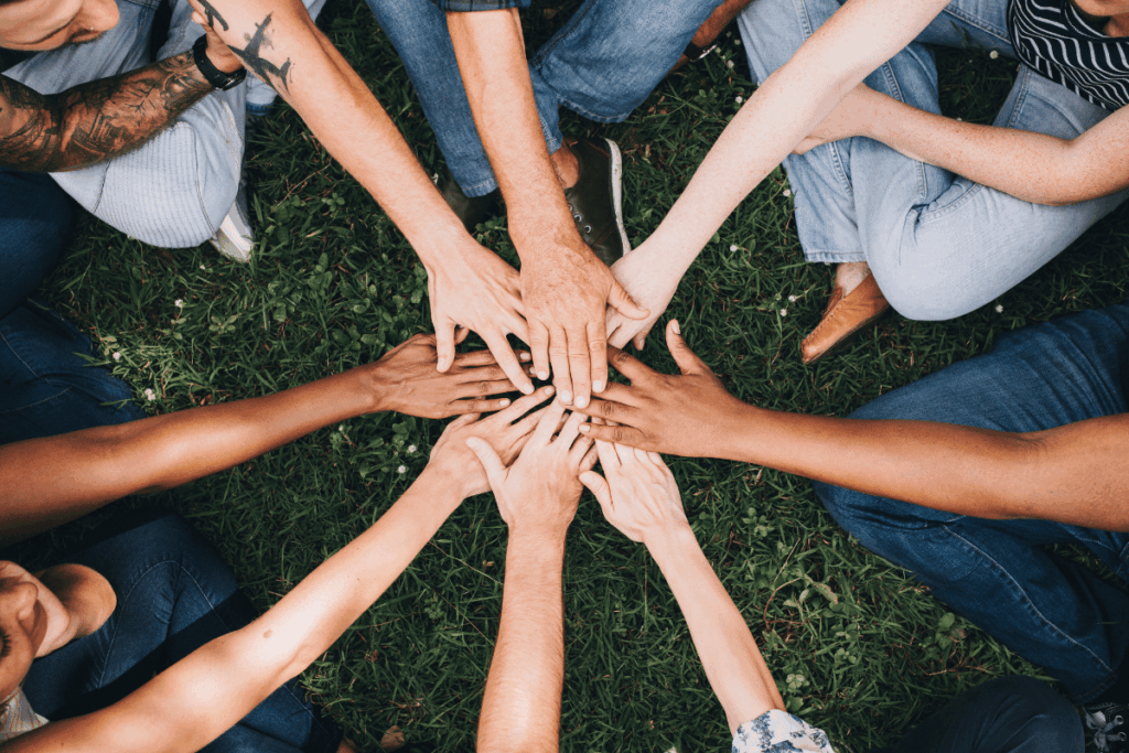 overhead shot of grou of people put there hands on top of each other in a circle