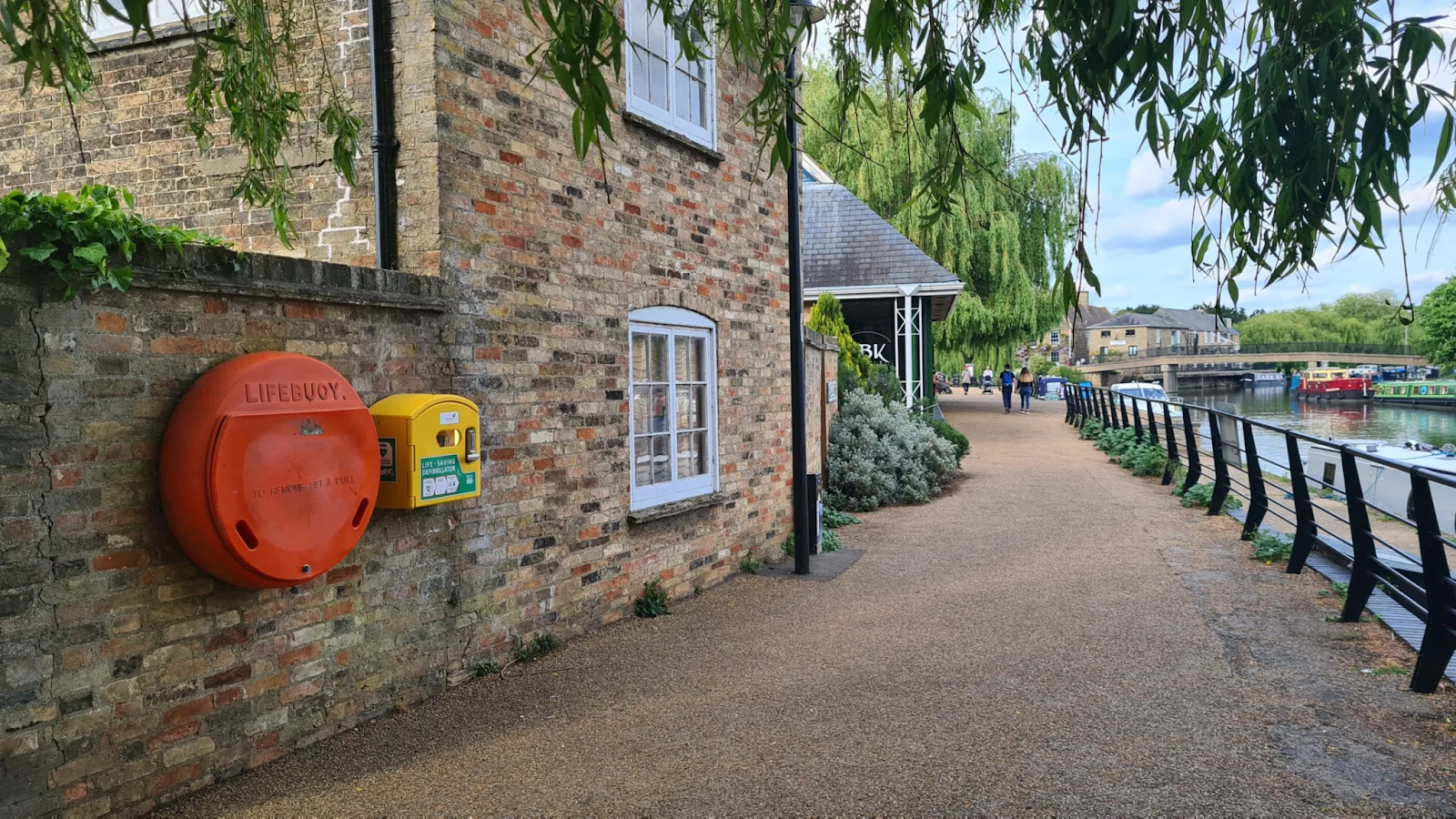 Automated External Defibrillator (AED) station in a public area alongside a lifebuoy, providing essential emergency cardiac care access for the community.
