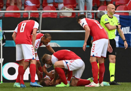 Denmark players help Denmark's midfielder Christian Eriksen after he collapsed before the medics arrive during the UEFA EURO 2020 Group B football match between Denmark and Finland at the Parken Stadium in Copenhagen on June 12, 2021. (Photo by Jonathan NACKSTRAND / various sources / AFP)